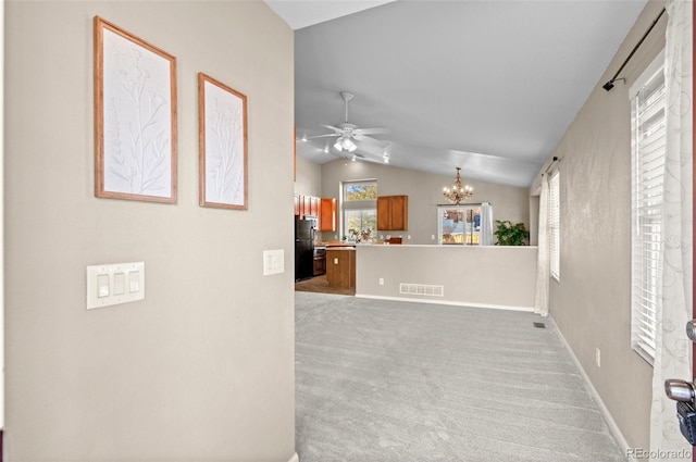 kitchen featuring black refrigerator, ceiling fan with notable chandelier, light colored carpet, and lofted ceiling