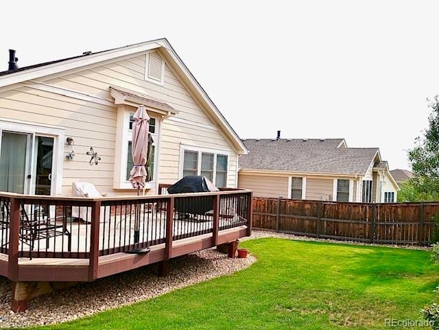 back of property featuring a deck and a yard