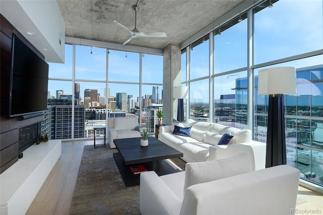 1700 Bassett St Unit 2315, Denver, CO 80202 - living room with a wall of windows, a view of skyline, ceiling fan, and wood finished floors