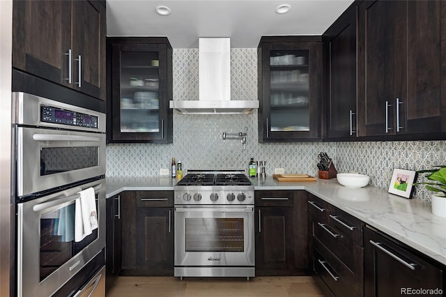 1700 Bassett St Unit 2315, Denver, CO 80202 - kitchen featuring appliances with stainless steel finishes, wall chimney exhaust hood, glass insert cabinets, backsplash, and recessed lighting