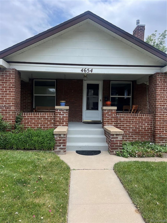 4654 Bryant St, Denver, CO 80211 - view of front of home with covered porch, brick siding, and a chimney