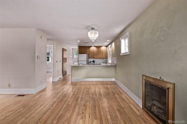 4654 Bryant St, Denver, CO 80211 - kitchen featuring freestanding refrigerator, healthy amount of natural light, light wood finished floors, and a peninsula