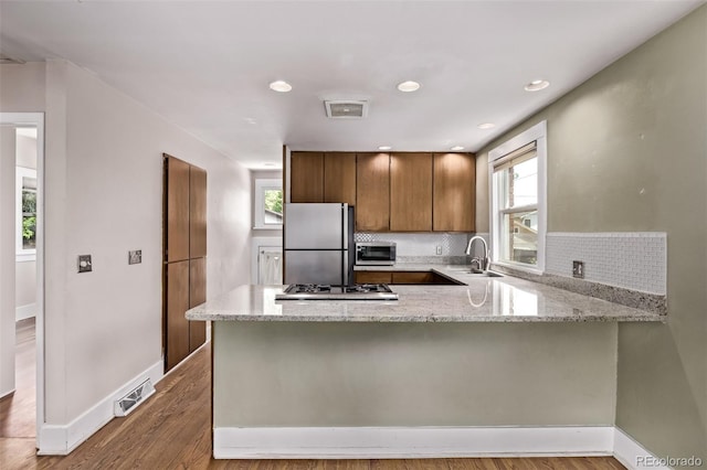 4654 Bryant St, Denver, CO 80211 - kitchen with stainless steel appliances, a peninsula, healthy amount of natural light, light stone counters, and recessed lighting