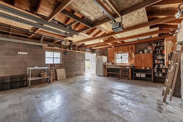 4654 Bryant St, Denver, CO 80211 - garage with freestanding refrigerator, a garage door opener, a workshop area, and concrete block wall