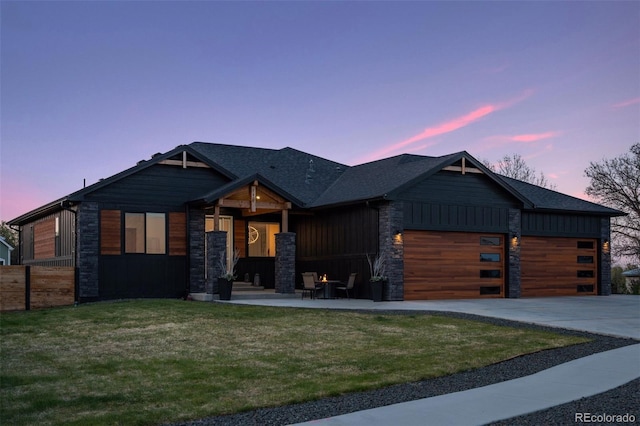 740 W County Road 10e, Berthoud, CO 80513 - view of front of home with fence, an attached garage, stone siding, a lawn, and driveway