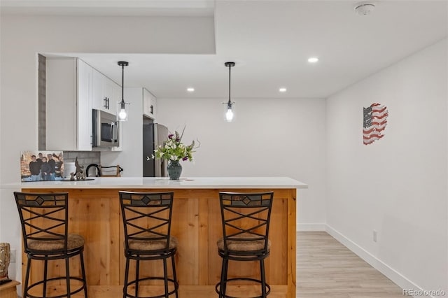 740 W County Road 10e, Berthoud, CO 80513 - kitchen with appliances with stainless steel finishes, light countertops, a kitchen breakfast bar, a peninsula, and white cabinetry