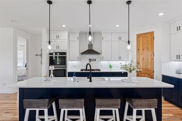 740 W County Road 10e, Berthoud, CO 80513 - kitchen with backsplash, stainless steel double oven, light countertops, white cabinets, and wall chimney exhaust hood