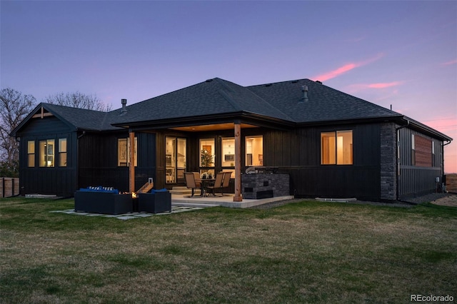 740 W County Road 10e, Berthoud, CO 80513 - back of property at dusk featuring a lawn, a patio, a shingled roof, and an outdoor hangout area
