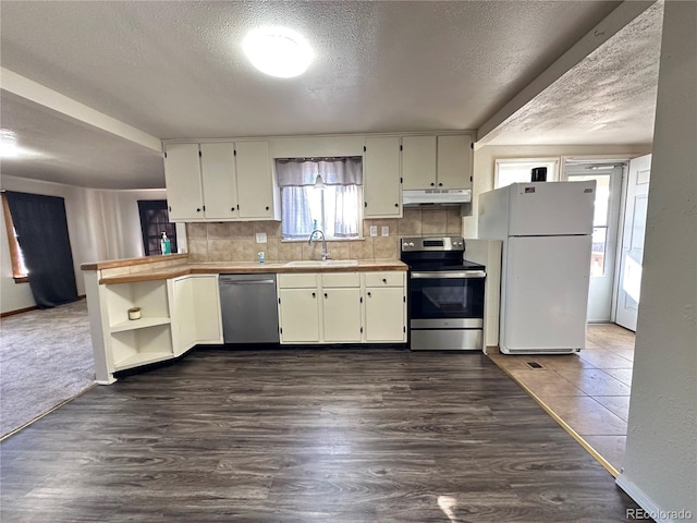 kitchen with appliances with stainless steel finishes, backsplash, dark hardwood / wood-style flooring, a textured ceiling, and sink