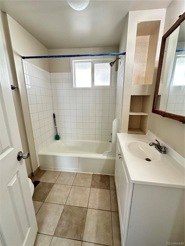 bathroom featuring tile patterned flooring, tiled shower / bath, and vanity