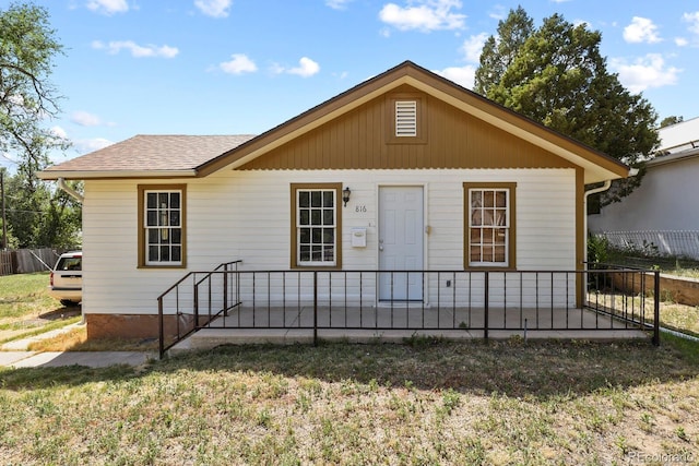 back of house with a porch and a yard