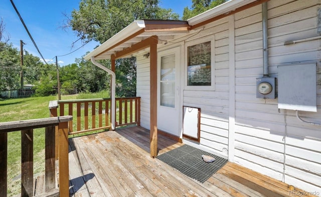 wooden deck featuring a lawn