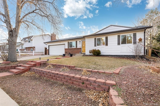 ranch-style house with entry steps, concrete driveway, a chimney, an attached garage, and brick siding