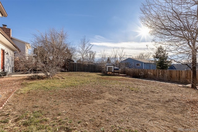 view of yard with an outbuilding, a storage unit, and fence