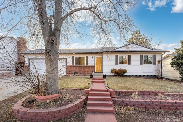 ranch-style home featuring a garage, a front yard, brick siding, and a chimney