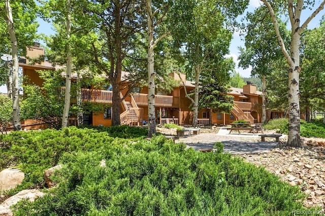 401 Forest Edge Rd Unit B2, Woodland Park, CO 80863 - back of house with stairway, a patio, and a chimney