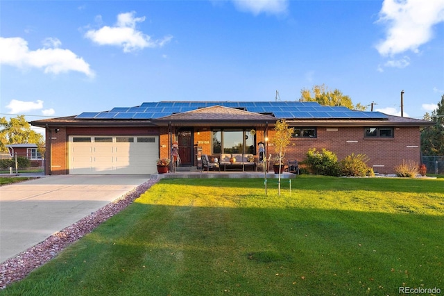 view of front of home with a front yard, a garage, and solar panels