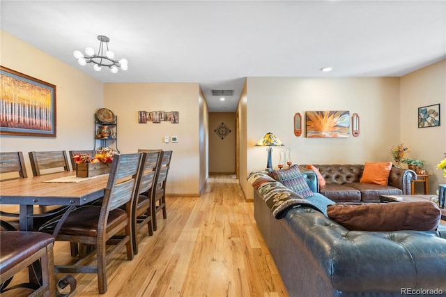 living room with light hardwood / wood-style flooring and a notable chandelier