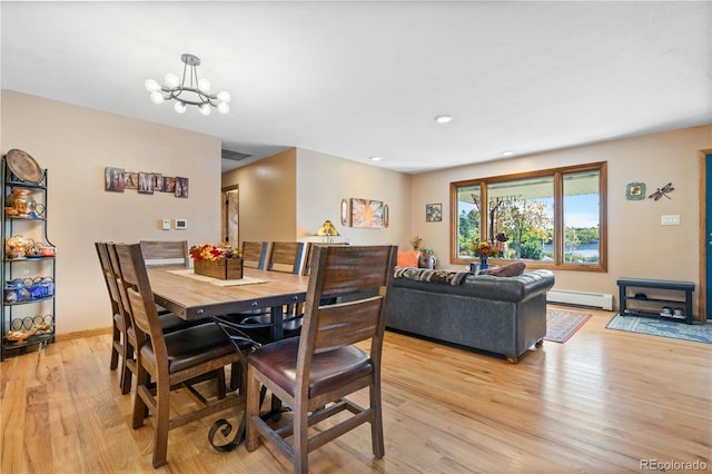 dining space with a baseboard radiator, light hardwood / wood-style flooring, and an inviting chandelier