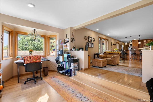 office with light hardwood / wood-style flooring and a chandelier