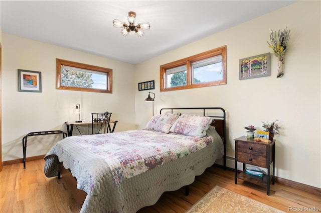 bedroom featuring a chandelier and light wood-type flooring