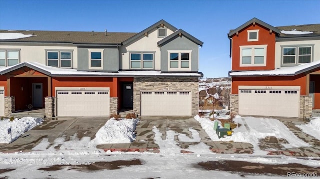 view of front of home with an attached garage, stone siding, concrete driveway, and stucco siding