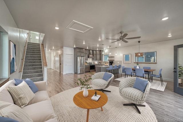 living room with light hardwood / wood-style flooring and ceiling fan