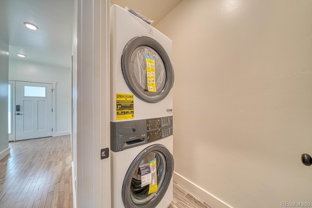 laundry area featuring light hardwood / wood-style floors and stacked washer / dryer