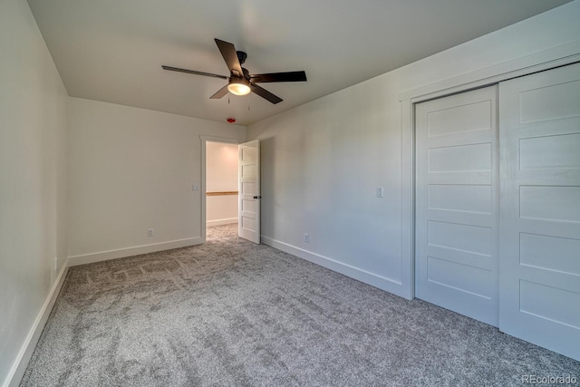 unfurnished bedroom featuring ceiling fan, a closet, and light carpet