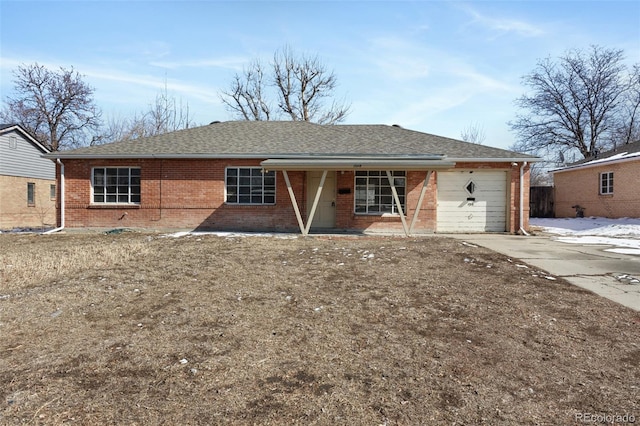 ranch-style home featuring an attached garage, driveway, roof with shingles, and brick siding