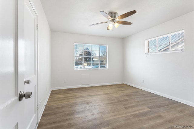 empty room with a ceiling fan, baseboards, and wood finished floors