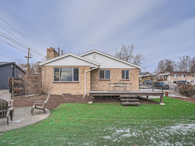 rear view of house featuring a yard and a wooden deck