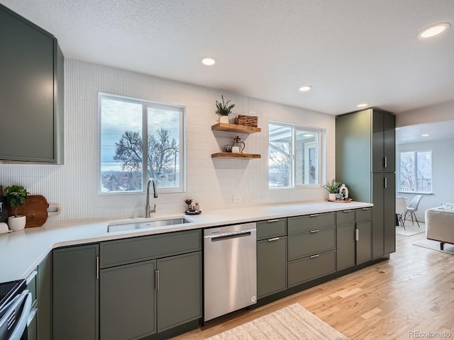 kitchen featuring sink, stainless steel appliances, a textured ceiling, and light hardwood / wood-style flooring