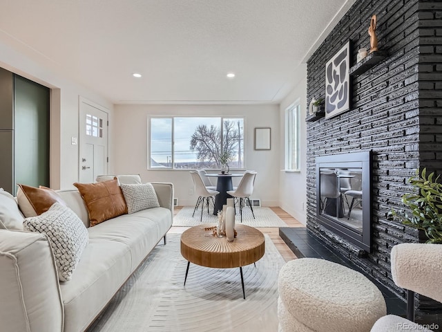 living room featuring hardwood / wood-style floors, a fireplace, and a textured ceiling