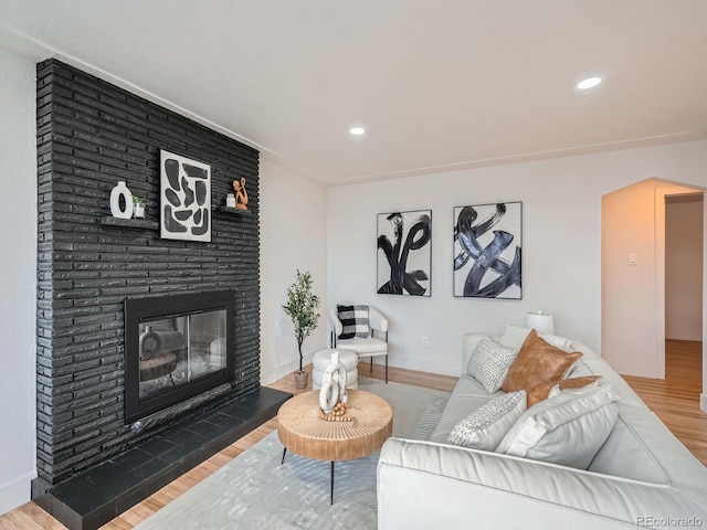 living room featuring hardwood / wood-style floors and a brick fireplace