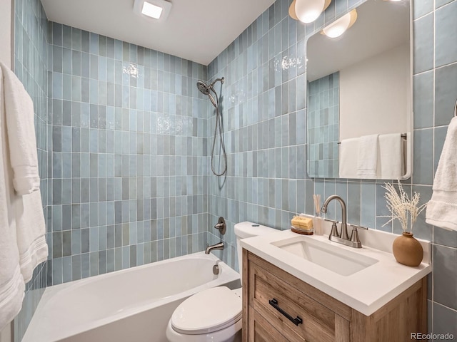 full bathroom featuring vanity, tiled shower / bath, toilet, tile walls, and tasteful backsplash