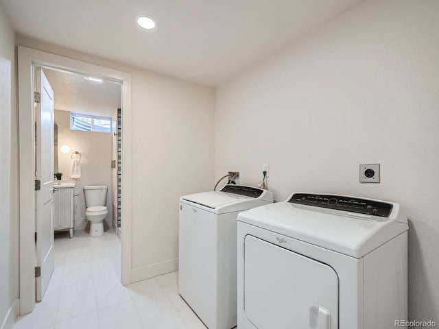 laundry room featuring washing machine and dryer and light tile patterned floors