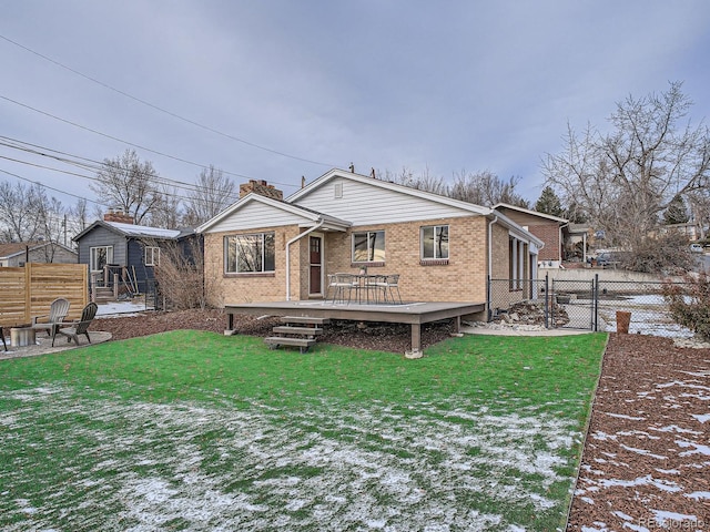 snow covered house featuring a yard and a wooden deck