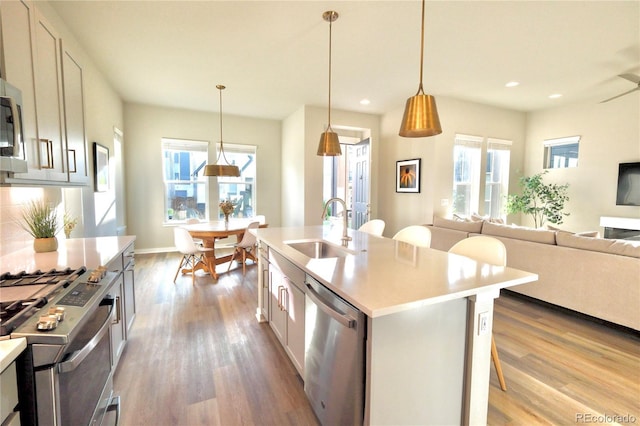 1919 W 165th Way, Broomfield, CO 80023 - kitchen featuring stainless steel appliances, wood finished floors, light countertops, recessed lighting, and plenty of natural light