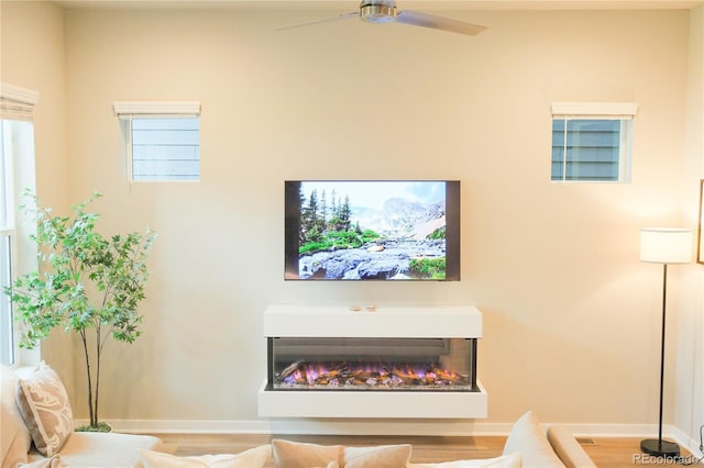 1919 W 165th Way, Broomfield, CO 80023 - living room featuring a ceiling fan, wood finished floors, and a warm lit fireplace