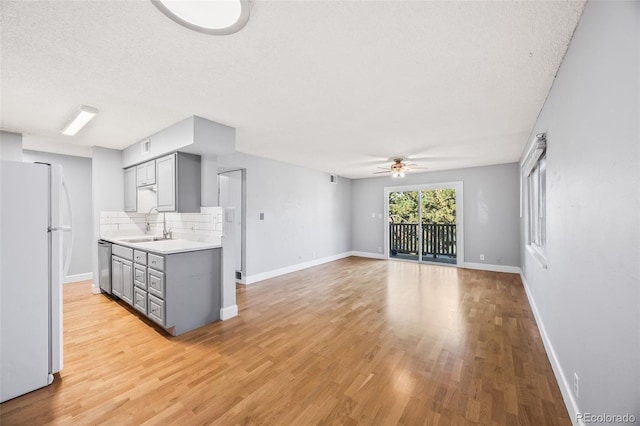 7495 E Quincy Ave Unit 208, Denver, CO 80237 - kitchen with gray cabinets, freestanding refrigerator, dishwasher, ceiling fan, and a textured ceiling