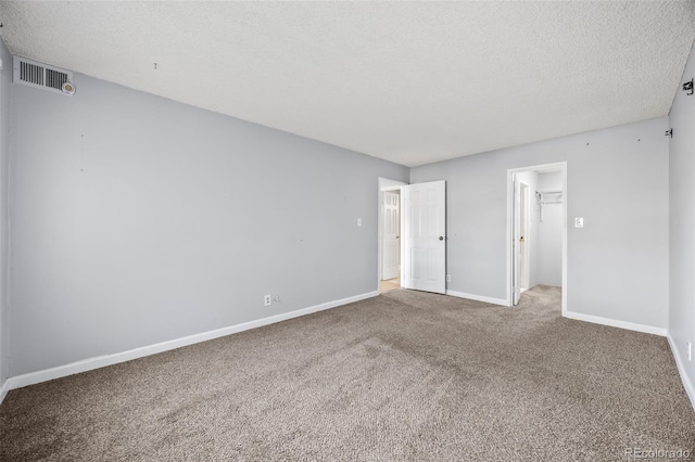 7495 E Quincy Ave Unit 208, Denver, CO 80237 - unfurnished bedroom with carpet, a textured ceiling, and a walk in closet