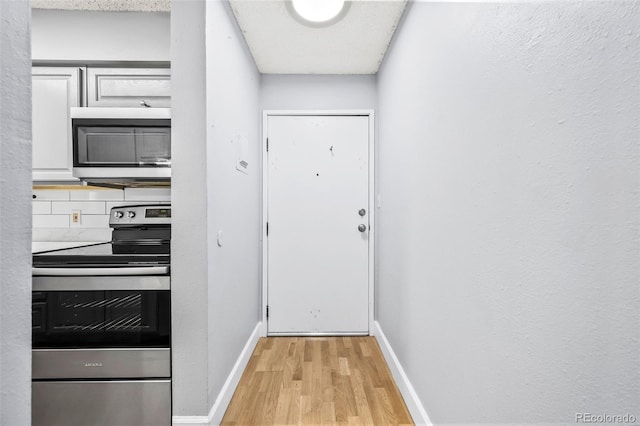 7495 E Quincy Ave Unit 208, Denver, CO 80237 - doorway with light wood-type flooring and baseboards