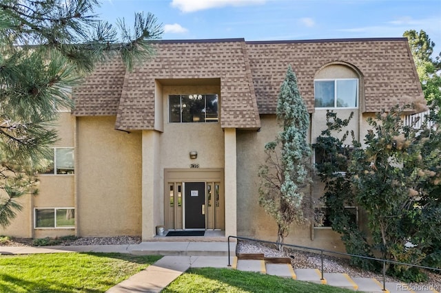7495 E Quincy Ave Unit 208, Denver, CO 80237 - view of front of house with a shingled roof, mansard roof, and stucco siding
