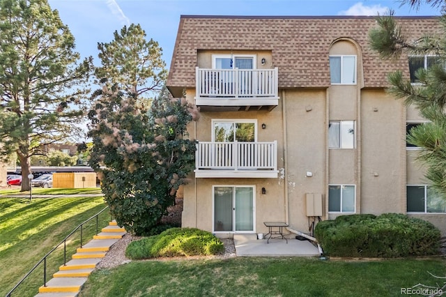 7495 E Quincy Ave Unit 208, Denver, CO 80237 - rear view of house featuring a balcony, mansard roof, a shingled roof, and stucco siding