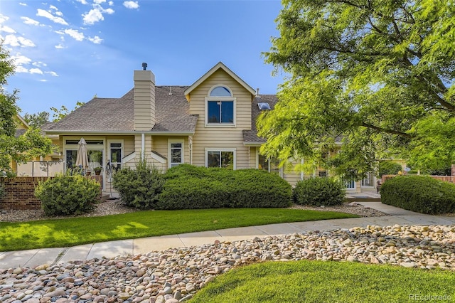 2117 S Troy Way, Aurora, CO 80014 - traditional-style home featuring roof with shingles, a front yard, and a chimney