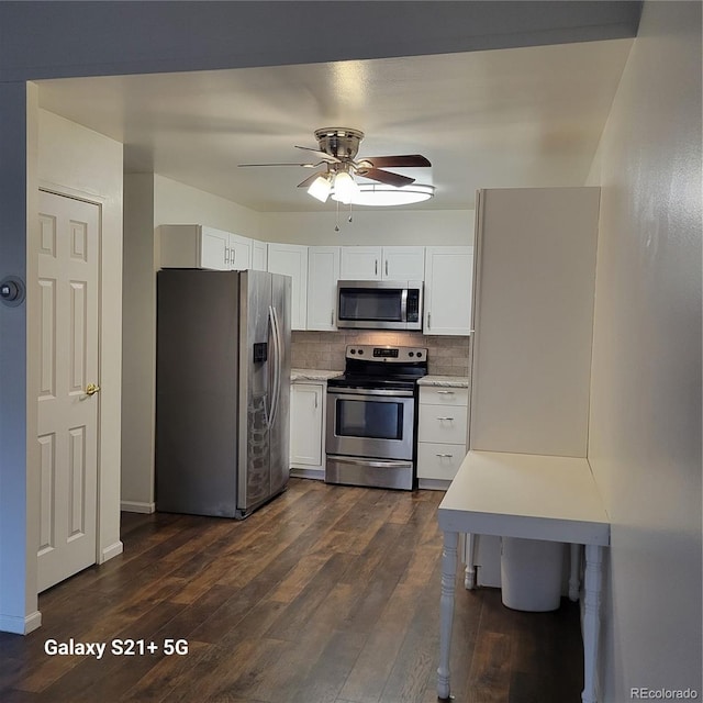 kitchen with dark wood-style floors, appliances with stainless steel finishes, light countertops, and backsplash