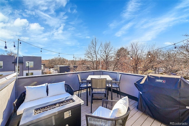 wooden deck with a grill, outdoor dining area, and an outdoor living space with a fire pit