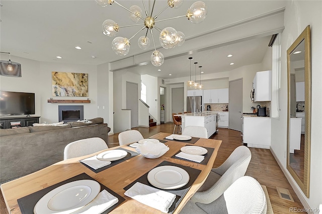 dining room featuring dark wood-style floors, recessed lighting, visible vents, and a fireplace