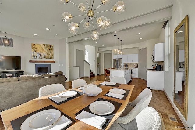 dining space with visible vents, stairway, an inviting chandelier, recessed lighting, and dark wood-type flooring